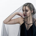 Black veil made of delicate sheer fabric draping over the model’s head and shoulders for sheer bride wedding use