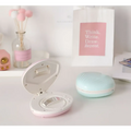 Pink and white seashell-shaped compact mirror with sleek rounded design for shell rainbow projection hair removal light