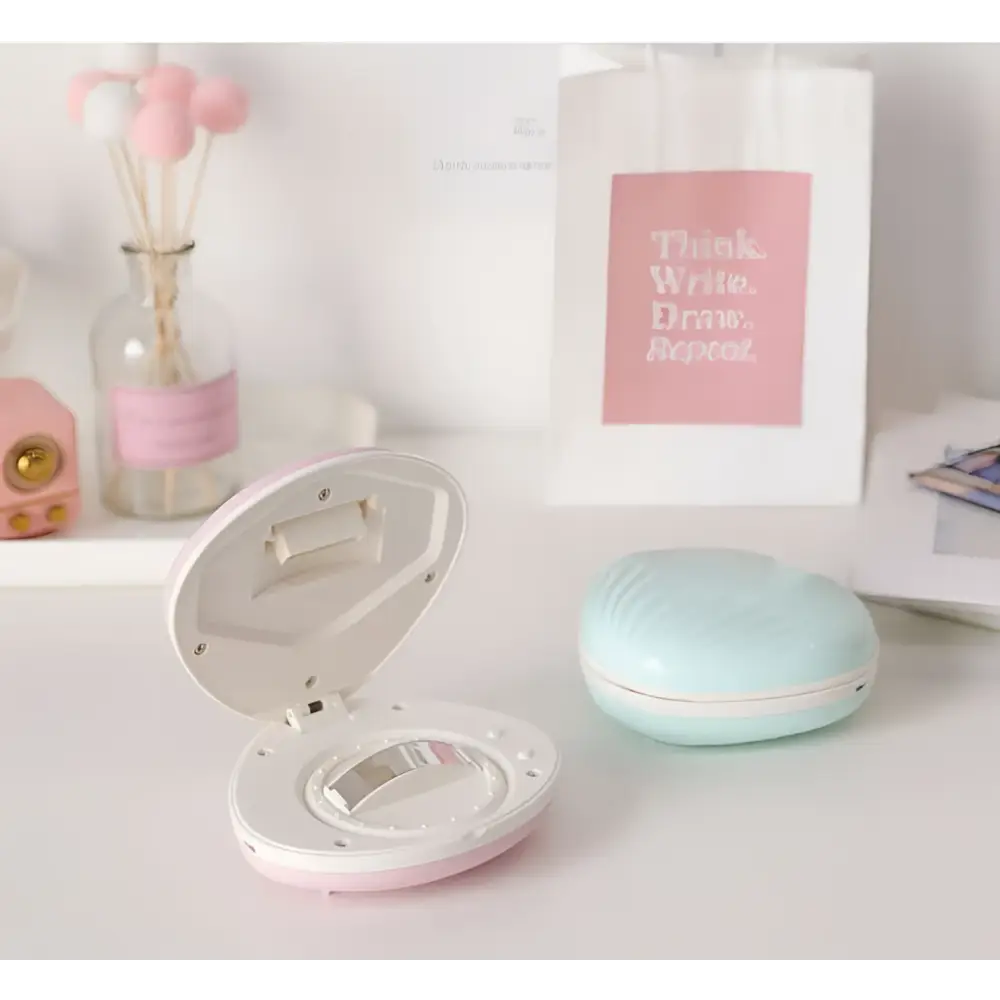 Pink and white seashell-shaped compact mirror with sleek rounded design for shell rainbow projection hair removal light