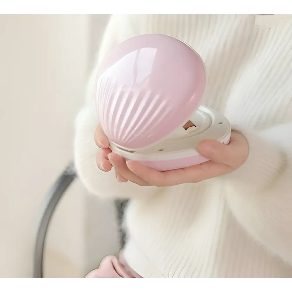 Pink seashell-shaped compact rainbow projection hair removal light with glowing purple light inside for effective use