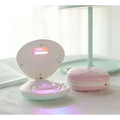 Pink seashell-shaped compact rainbow projection hair removal light with glowing purple light inside for effective use
