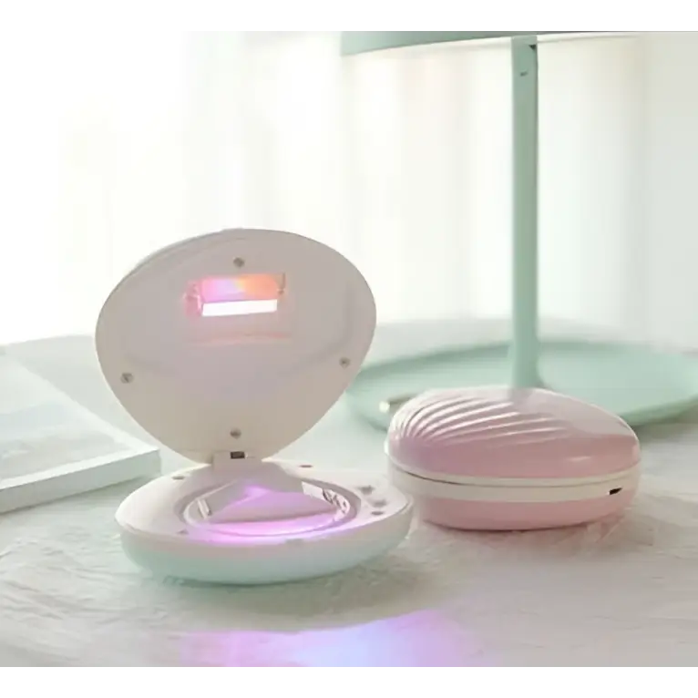 Pink seashell-shaped compact rainbow projection hair removal light with glowing purple light inside for effective use