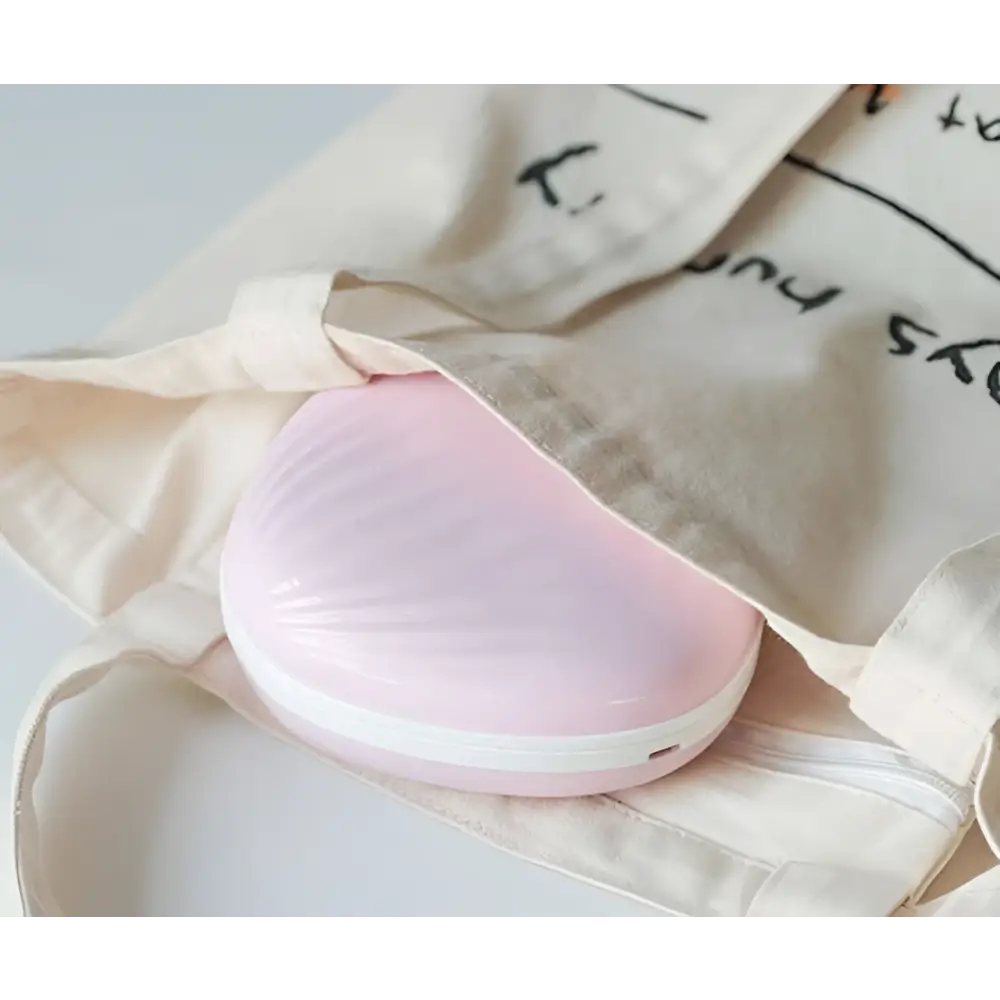 Pink heart-shaped portable heater with glossy plastic finish and white trim for shell rainbow projection hair use