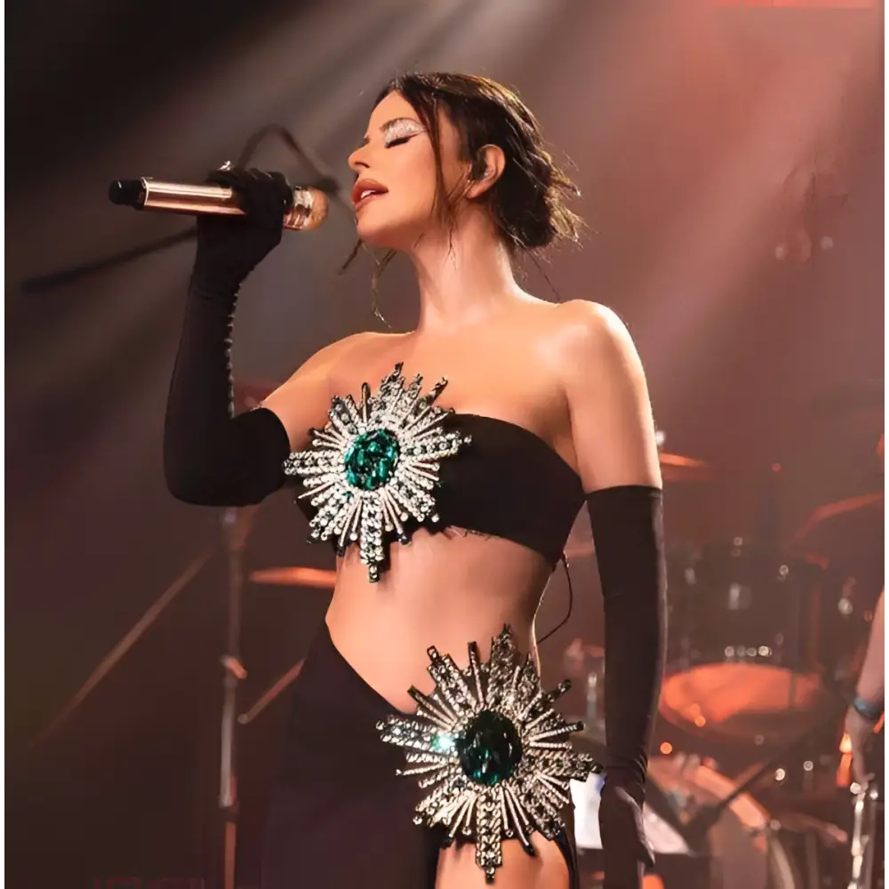 A black strapless slit skirt bandage suit with shiny rhinestone tube material and emerald crystal sunburst embellishments