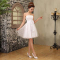 White strapless cream-colored tulle short tube top bride wedding dress with fitted bodice gathered waistband and large bow