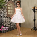 White strapless cream-colored tulle wedding dress with fitted bodice flared skirt and large bow at the waist
