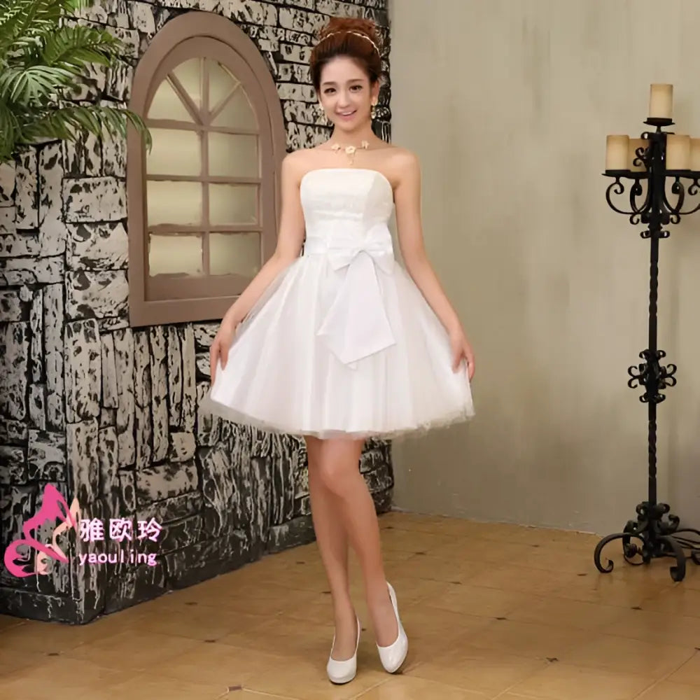 White strapless cream-colored tulle wedding dress with fitted bodice flared skirt and large bow at the waist