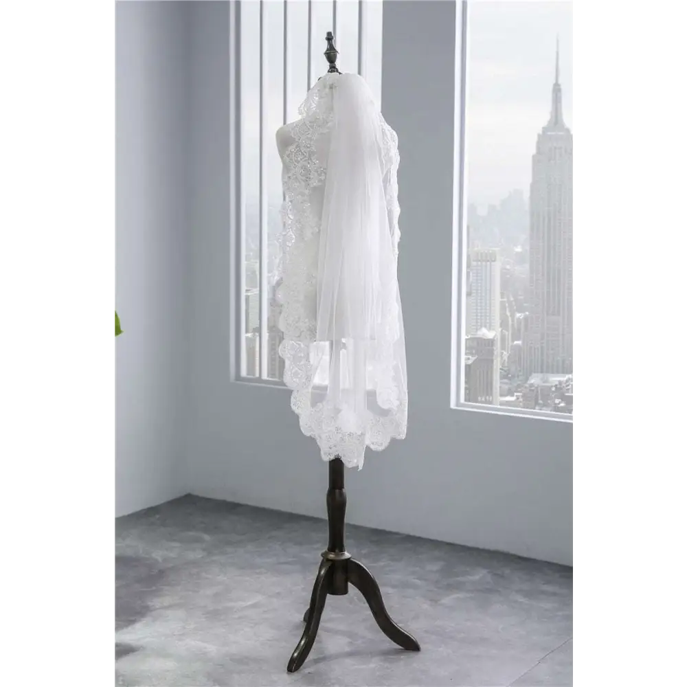 Short veil soft mesh sequined lace in white ivory with intricate floral patterns and scalloped edge on mannequin stand
