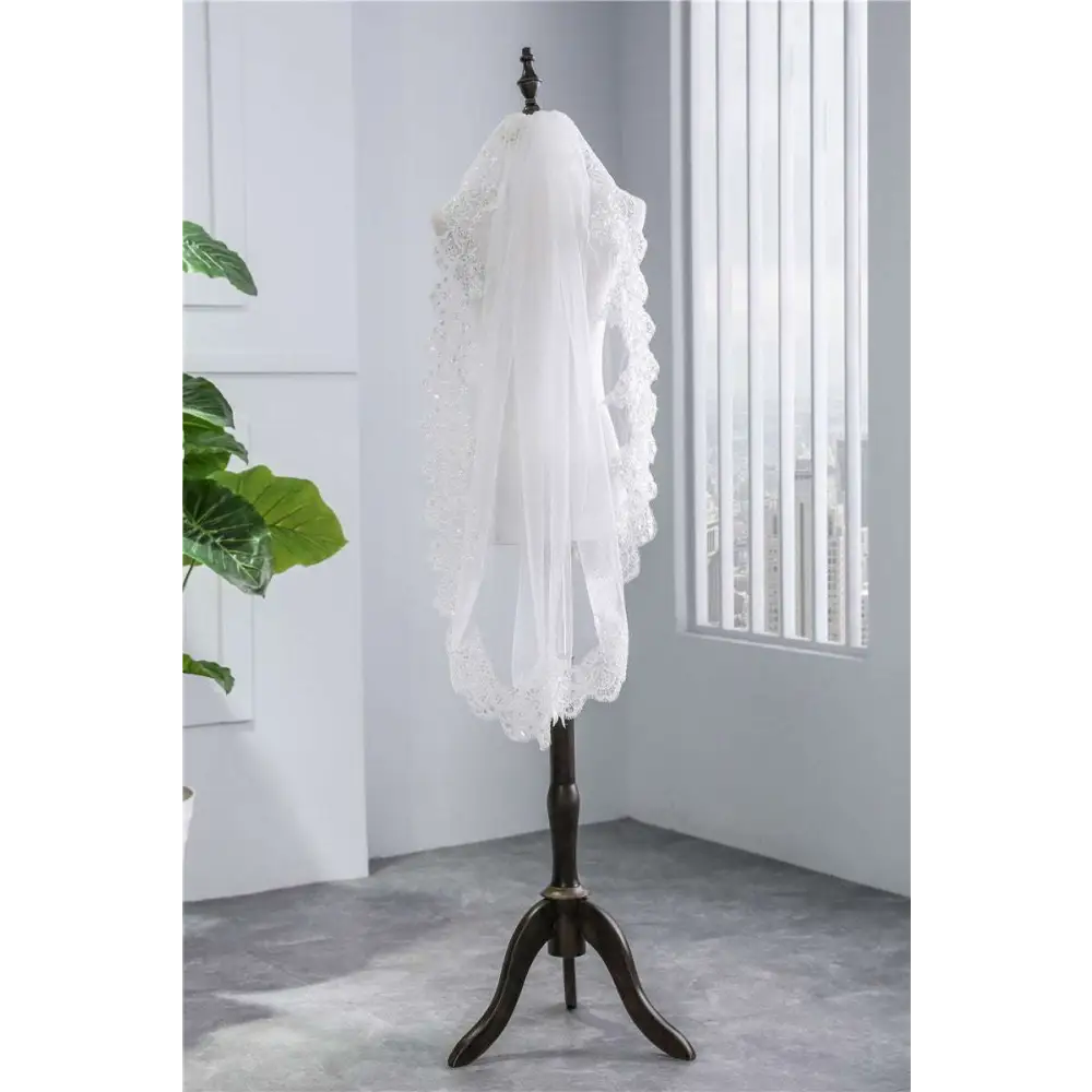 White short veil soft mesh sequined lace with intricate beaded scalloped edge displayed on dark wooden mannequin stand