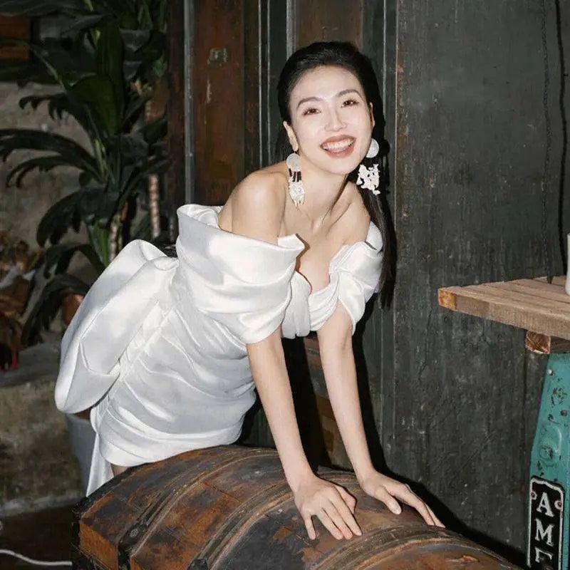 Short white color engagement dress made of white satin off-the-shoulder fabric with voluminous puffed sleeves
