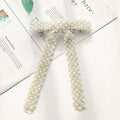 Elegant ivory pearl and crystal belt with woven mesh design complementing a silver beaded bow hair clip