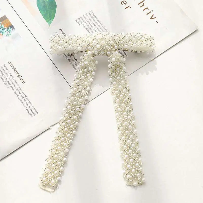 Elegant ivory pearl and crystal belt with woven mesh design complementing a silver beaded bow hair clip