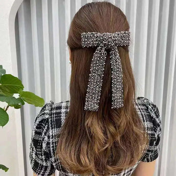 Silver beaded bow hair clip featuring sparkling metallic pearls and glass diamonds for an elegant hair accessory