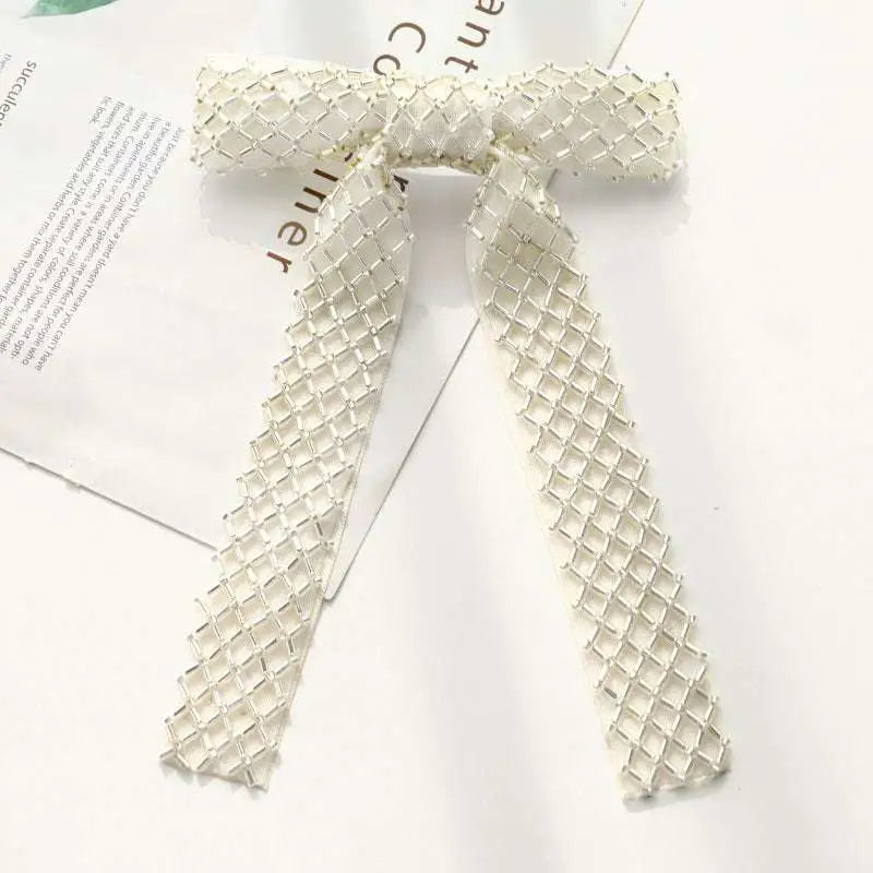 Silver beaded bow hair clip featuring an elegant off-white mesh with shimmering glass diamond pattern design