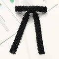 Black beaded bow tie made of small uniform beads in a classic design featured in a silver beaded bow hair clip with glass diamonds