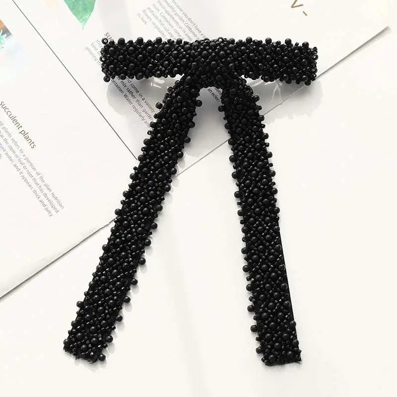 Black beaded bow tie made of small uniform beads in a classic design featured in a silver beaded bow hair clip with glass diamonds