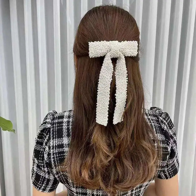Delicate white pearl-adorned silver beaded bow hair clip with glass diamonds and soft textured finish