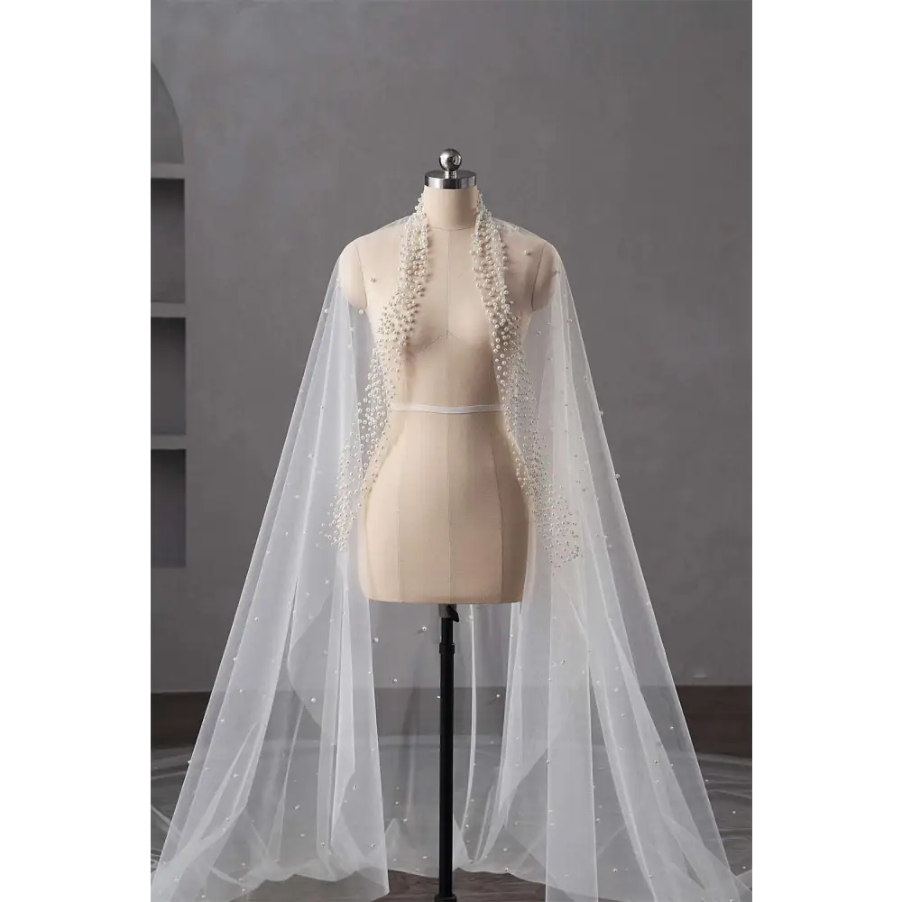 A silver beaded long bridal cathedral veil adorned with pearls and rhinestones elegantly frames the bride’s hair