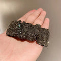 A sparkling black rhinestone bow hair clip featuring hot rhinestone details in a silver bow pleated bb clip design