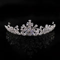A sparkling silver bride headdress crown with intricate floral designs and clear crystals in a necklace jewelry suit