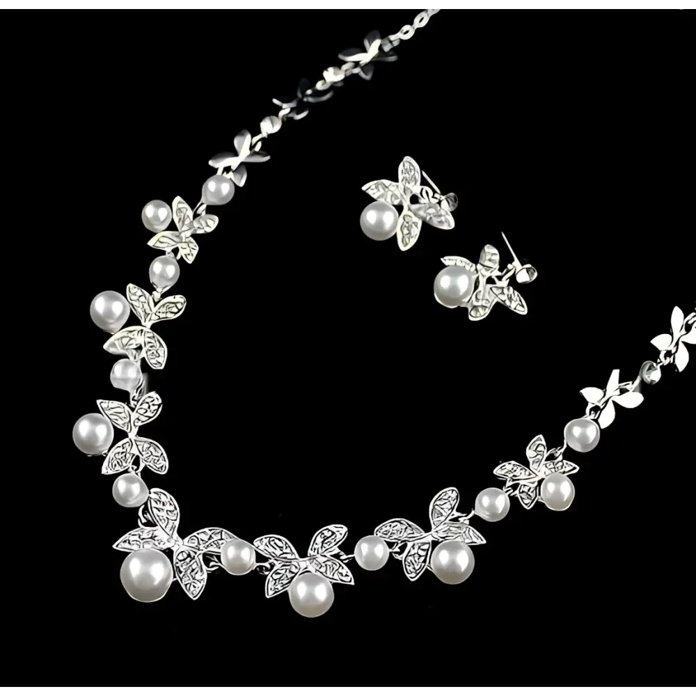 Silver butterfly bride wedding jewelry set featuring a silver necklace with butterfly and leaf motifs adorned with pearls