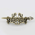 Antique brass-colored metal hair clip featuring intricate celtic knotwork in a silver celtic knot design