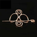 Rose gold metal hair clip with elegant swirling design and decorative spiral tip for a silver celtic knot look