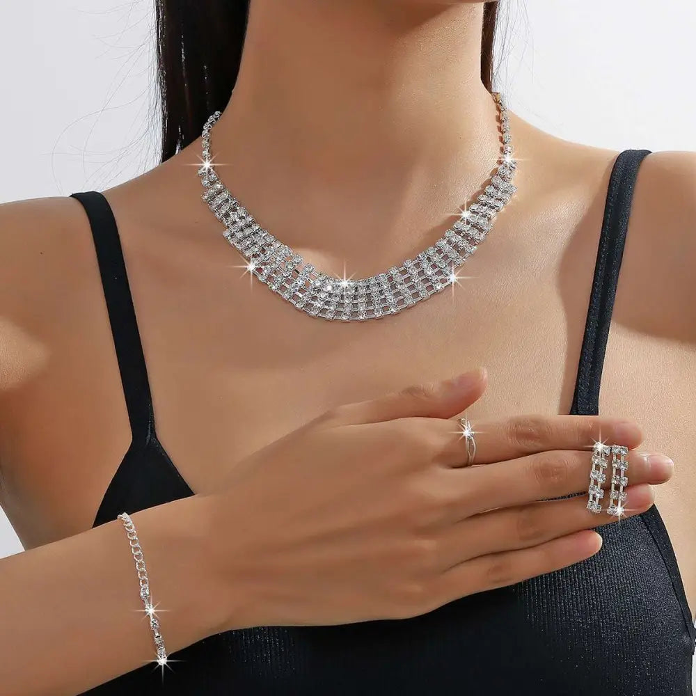 A silver claw chain necklace with multiple rows of clear rhinestones in a sleek layered design from the bracelet earrings ring set
