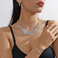 A silver claw chain necklace with multiple rows of clear rhinestones in a sleek layered design from the bracelet earrings ring set