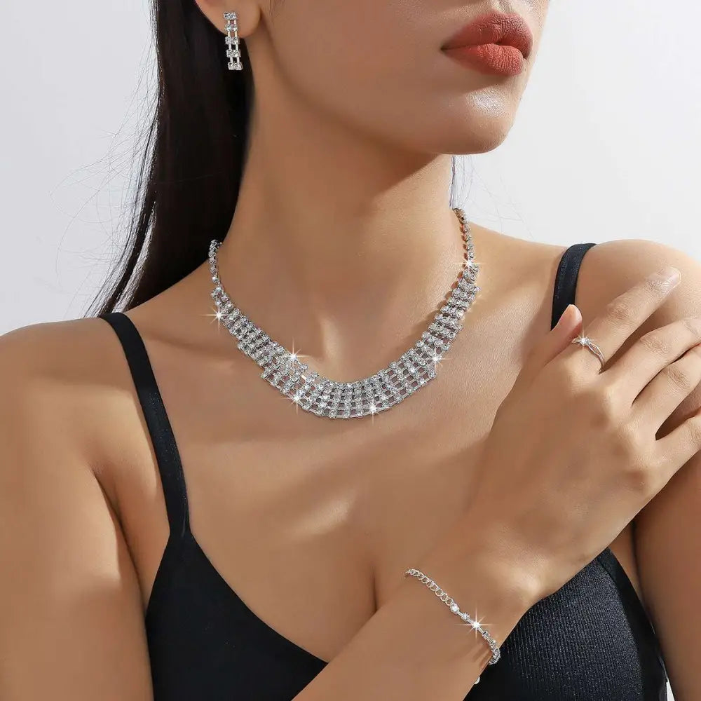 A silver claw chain necklace with multiple rows of clear rhinestones in a sleek layered design from the bracelet earrings ring set