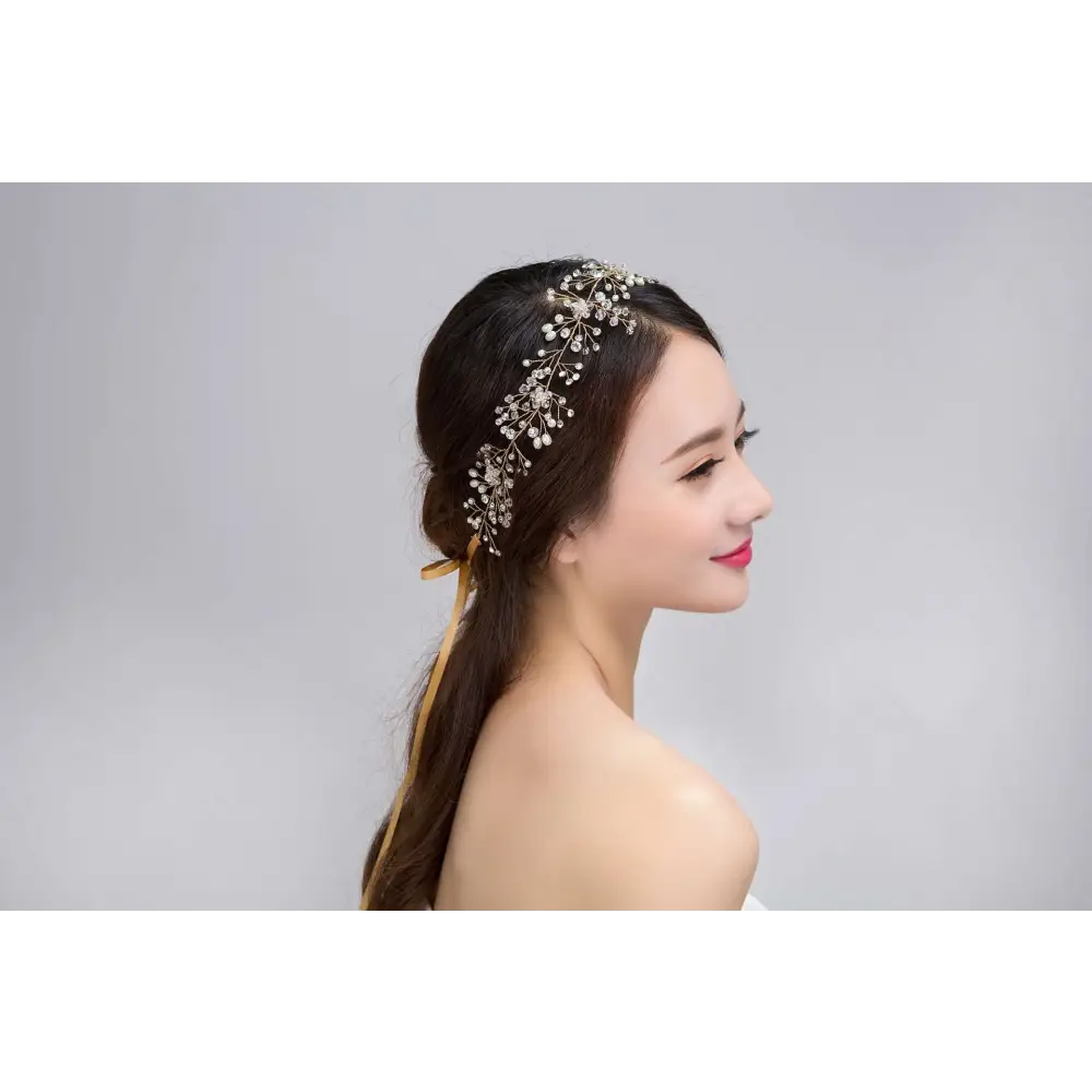 A delicate silver crystal bridal hair accessory with sparkling crystals and intricate leaf-like metalwork design