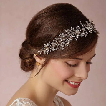 A delicate silver crystal bridal hair accessory with sparkling crystals and intricate leaf-like metalwork design