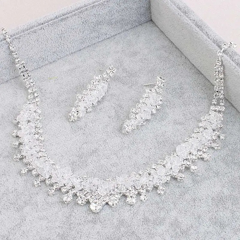 A silver crystal choker wedding jewelry set featuring a cascading crystal design with matching dangling earrings