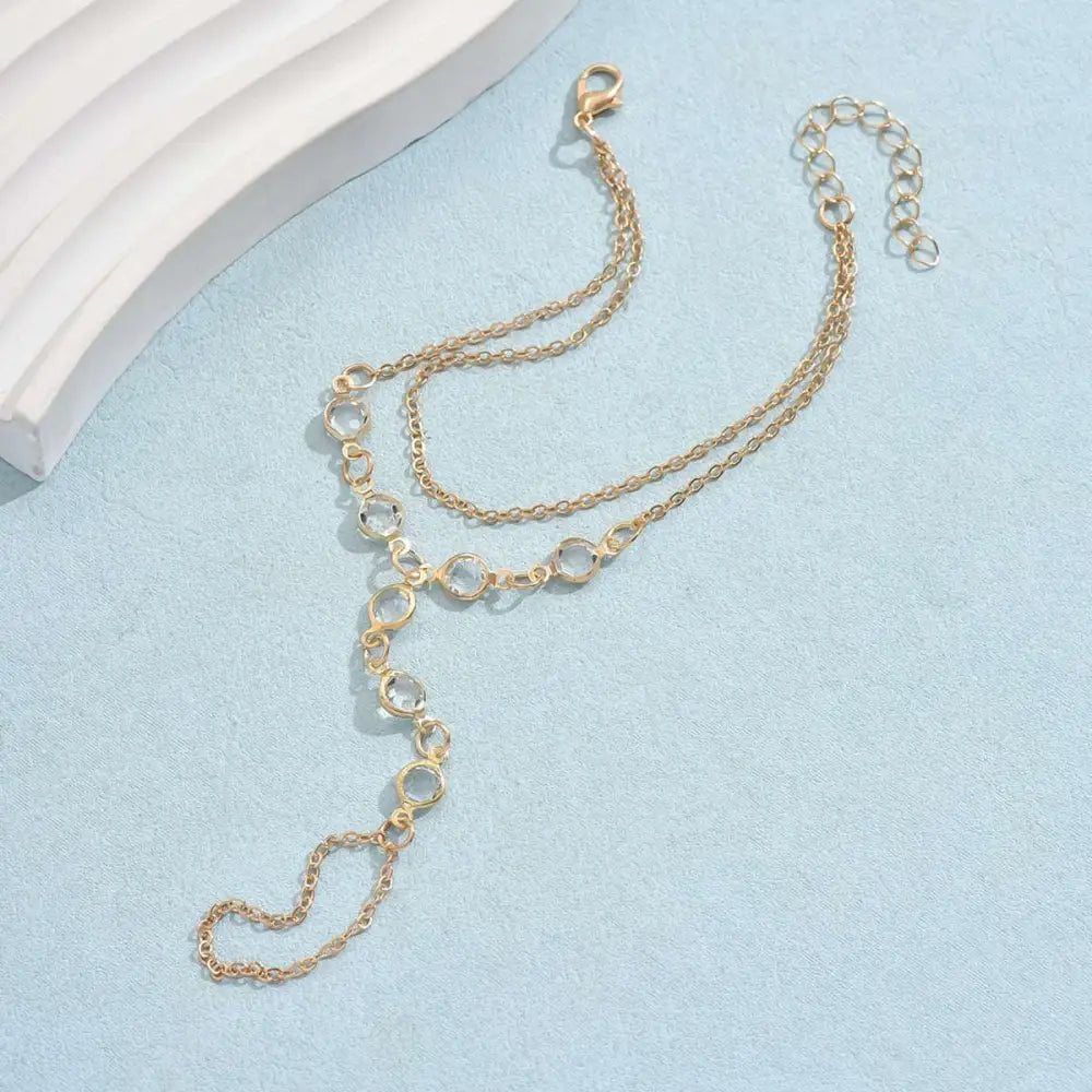 Gold-toned double-layer chain anklet with circular links and lobster clasp featured in silver crystal fashion minimalist bracelet ring collection