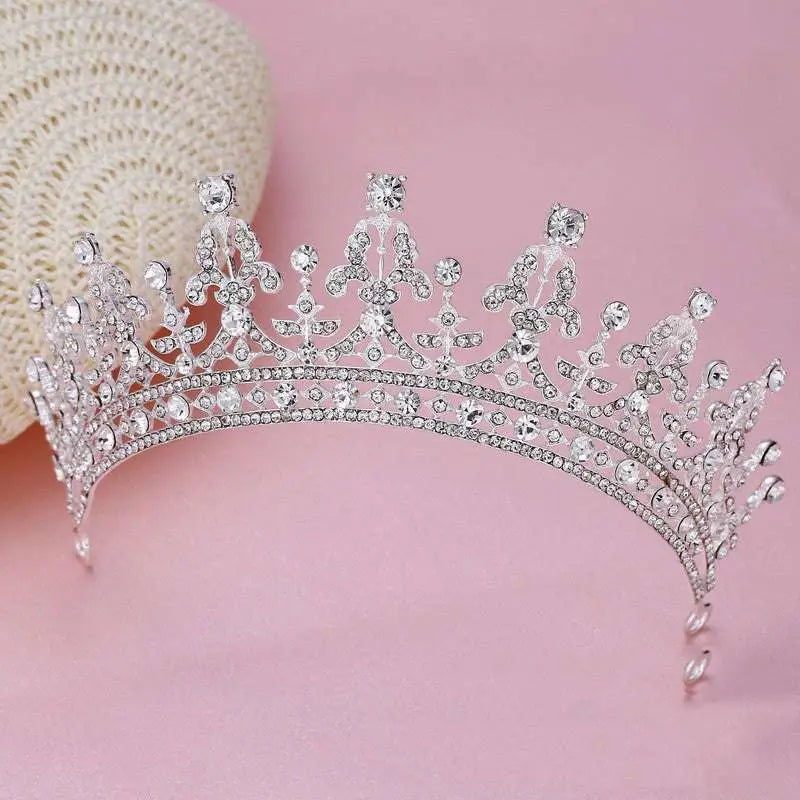 A silver crystal queen bridal wedding crown featuring a sparkling tiara with intricate crystal embellishments