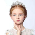 A silver crystal stage flower girl head tiara with intricate filigree and sparkling embedded crystals