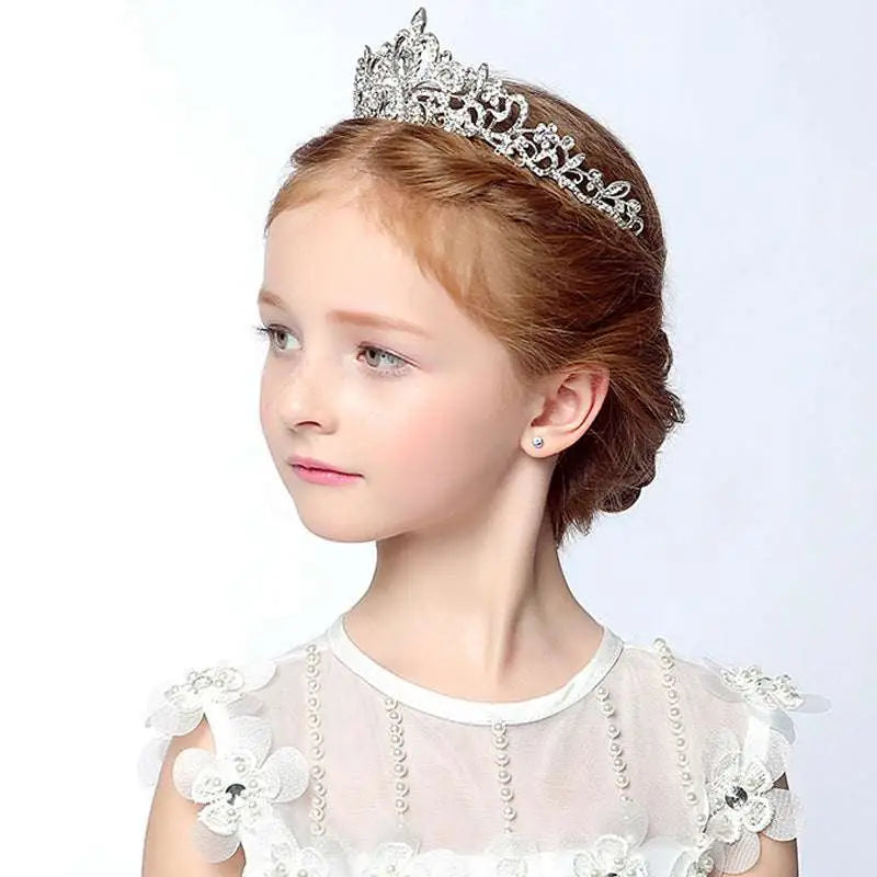 A delicate silver crystal stage flower girl head tiara adorned with sparkling rhinestones and floral designs