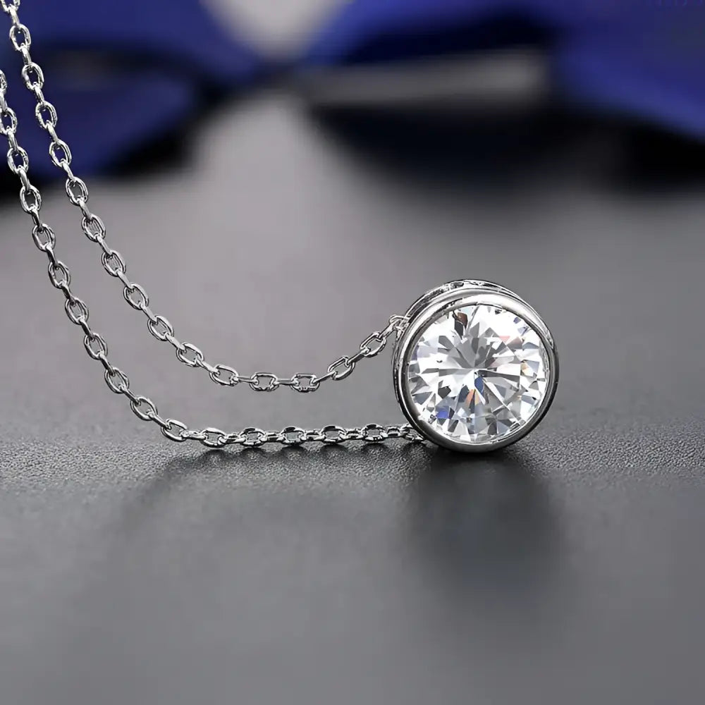A silver cubic zirconia necklace with a round cut stone in a minimalist bezel from a zirconia bride fashion accessories jewelry set