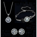 Silver diamond jewelry set featuring silver-toned necklace bracelet and earrings with round-cut clear stones surrounded by accents
