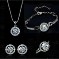 Silver diamond jewelry sets featuring a silver necklace, bracelet, earrings, and ring with sparkling circular halo stones