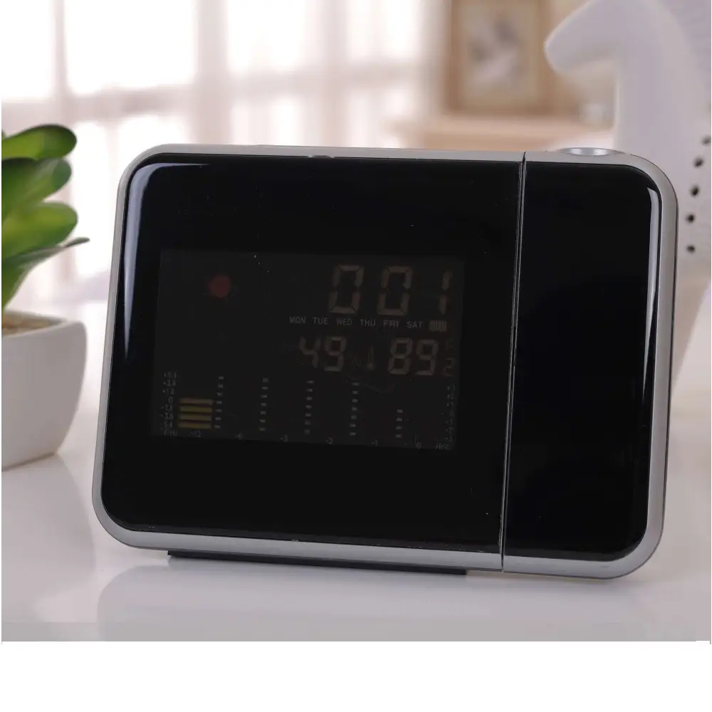Silver digital weather station home electronic clock with black screen and silver frame displaying time and temperature