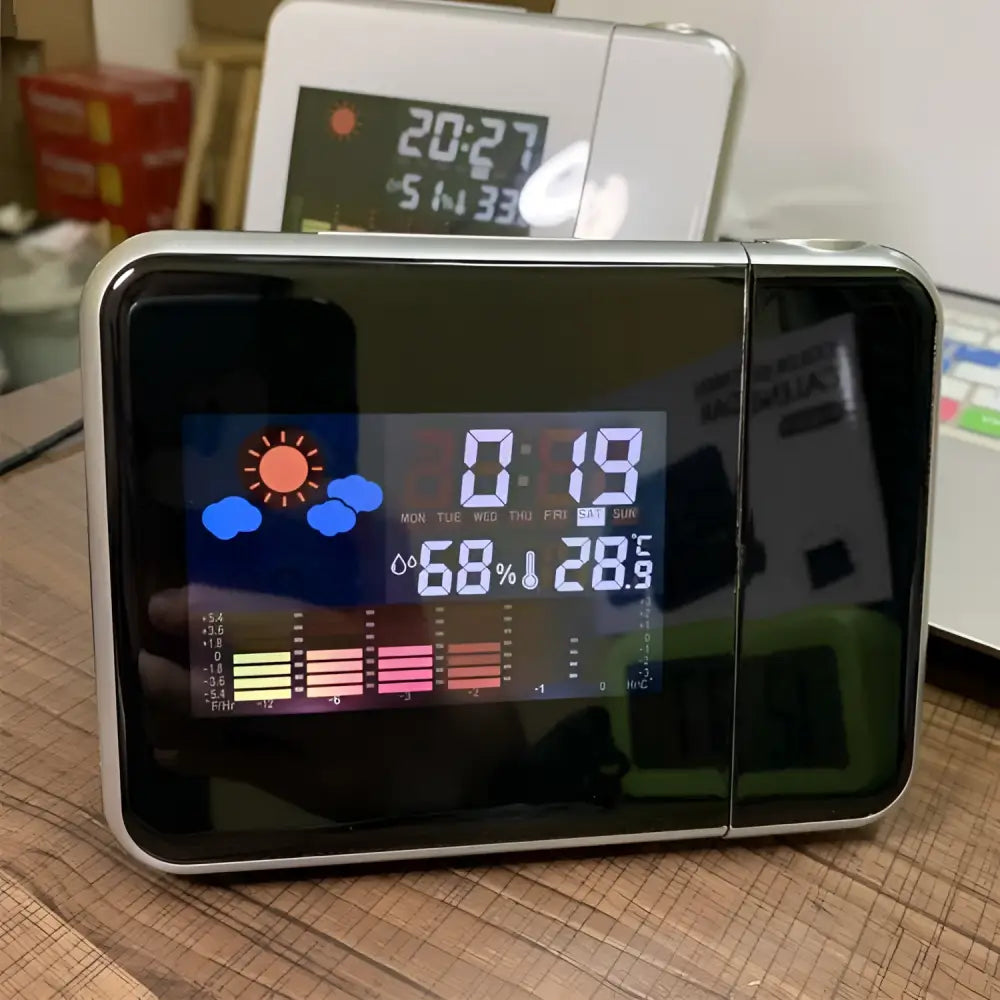 Silver digital weather station home electronic clock with silver frame displaying time temperature humidity and colorful forecast