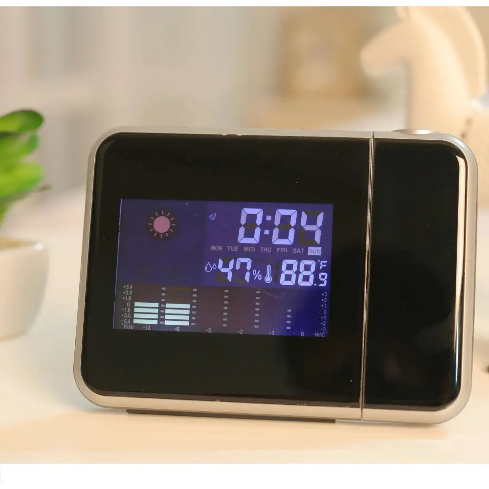 Silver digital weather station home electronic clock with black and silver design blue illuminated display showing time temperature and humidity