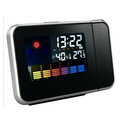 Silver digital weather station home electronic clock with black digital display silver trim showing time temperature humidity and forecast