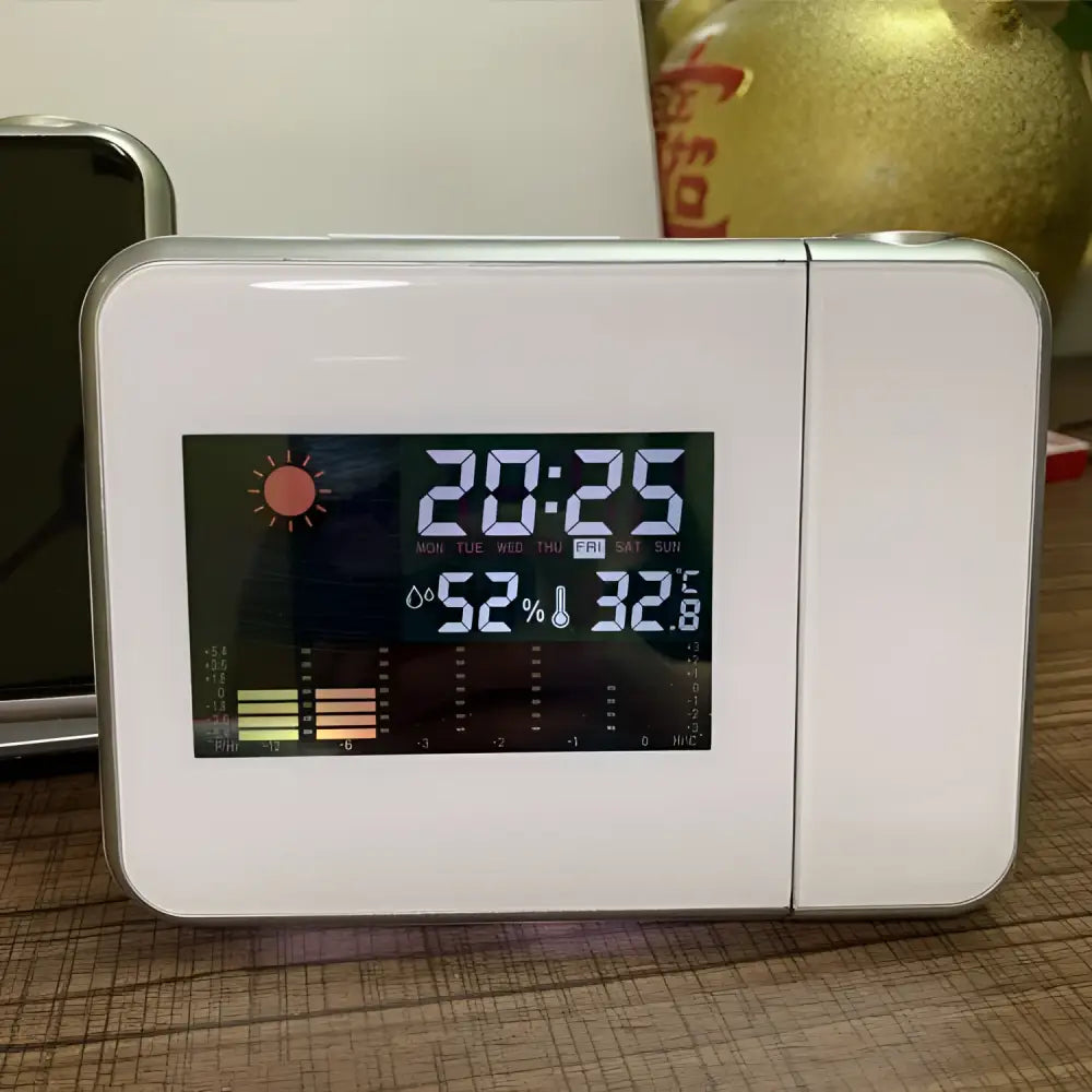 White rectangular digital weather station with silver frame displaying time temperature humidity and forecast home electronic clock
