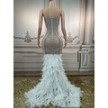 A silver feathered hips sleeveless long gown with intricate beading and a voluminous white feathered hips nightclub train