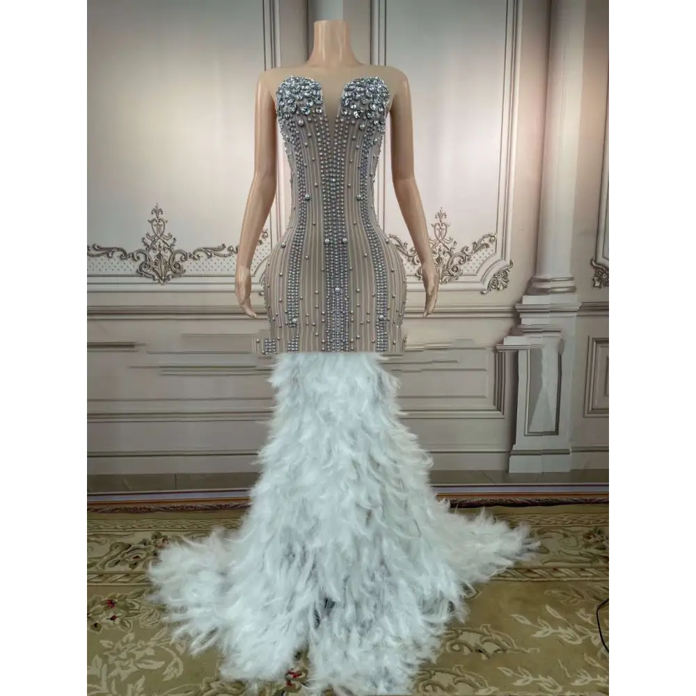 A glamorous sleeveless long gown in silver beading with feathered hips for nightclub bar events