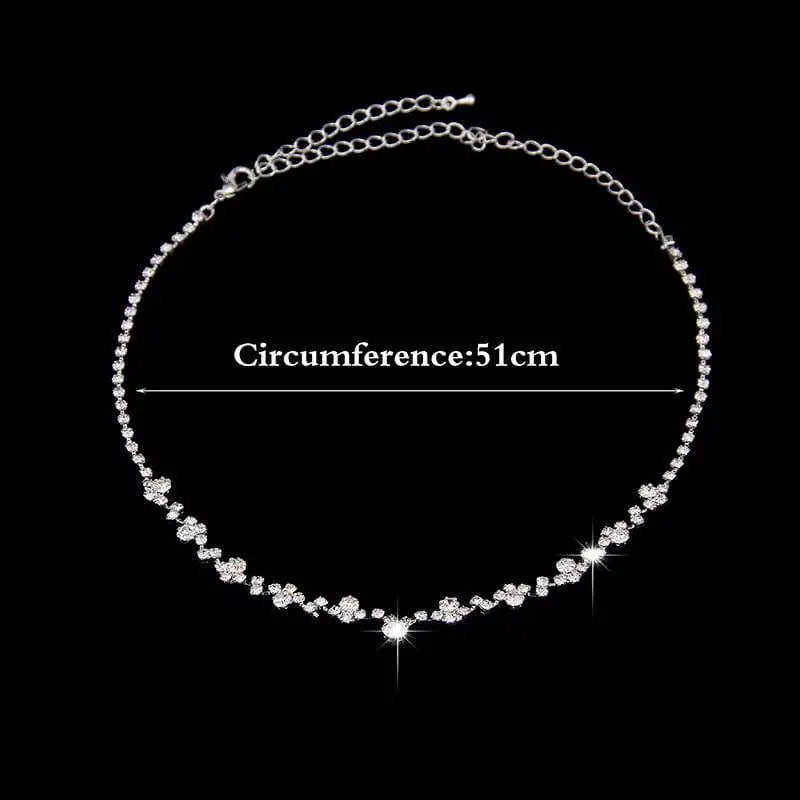 Silver floral bridal two piece necklace and earrings set featuring a delicate silver chain with sparkling crystal flowers