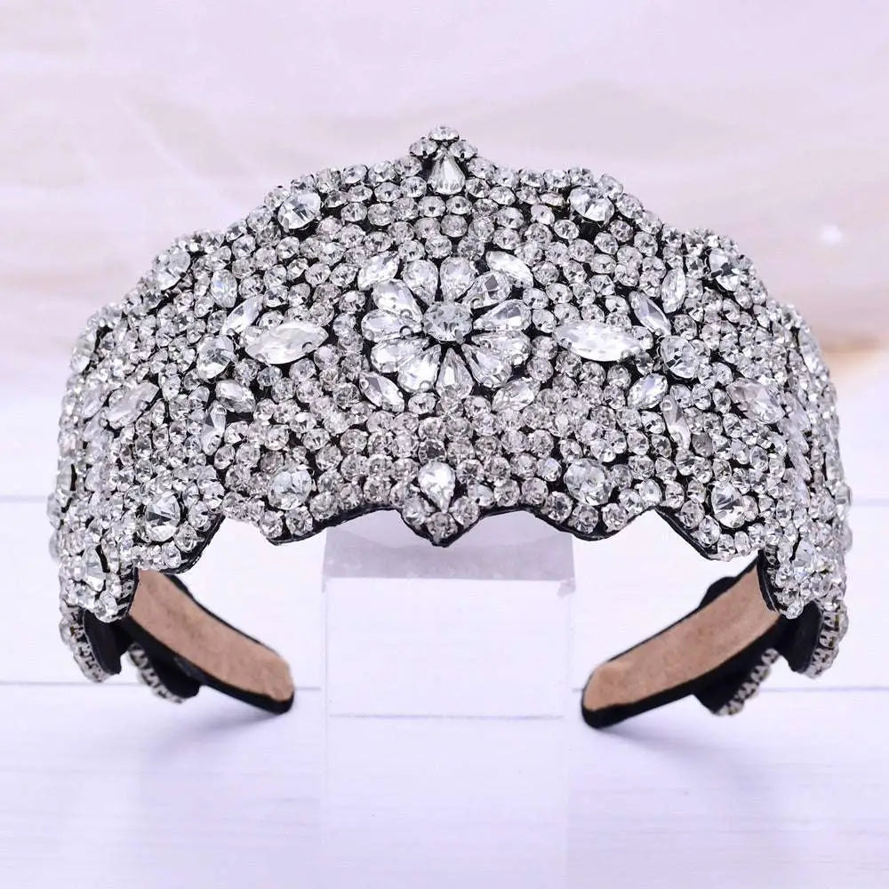 A sparkling silver rhinestone fashion retro headband with a silver floral rhinestone central design and scalloped edges