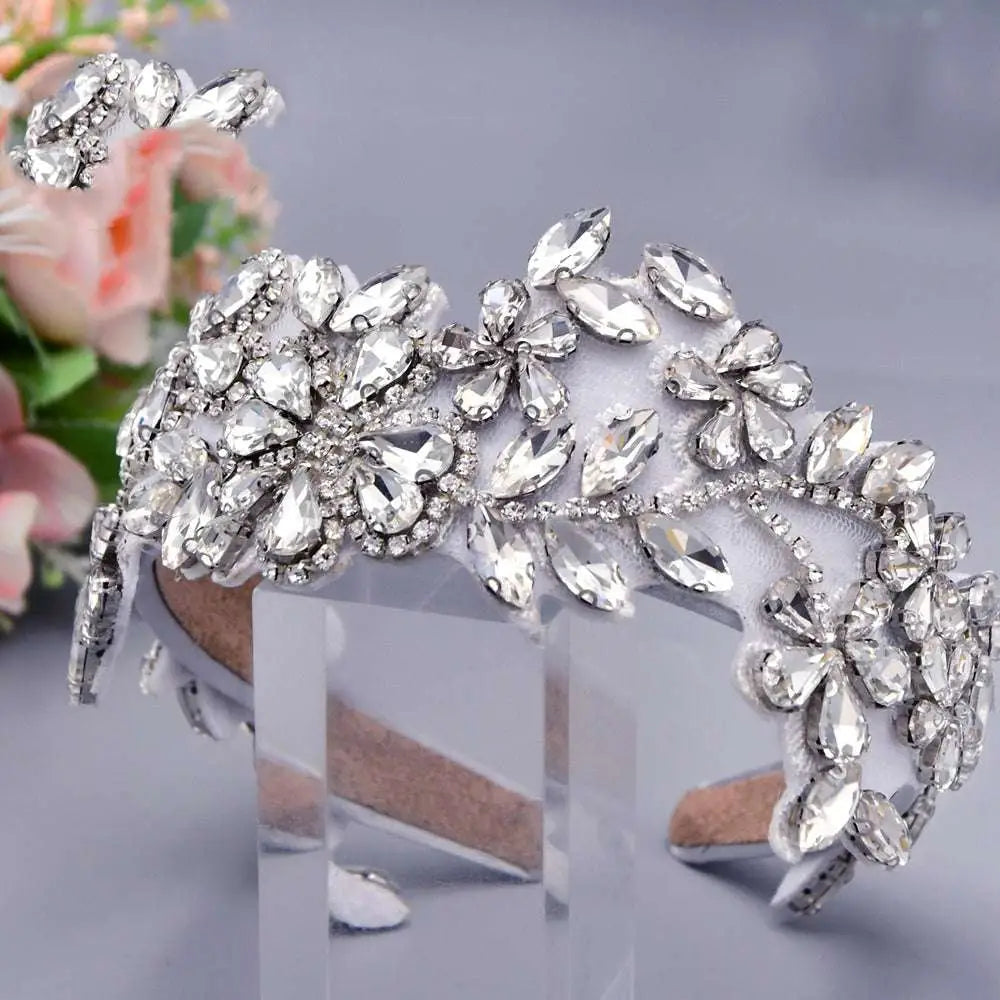 A sparkling silver rhinestone fashion retro headband with intricate silver floral rhinestone designs on a white base